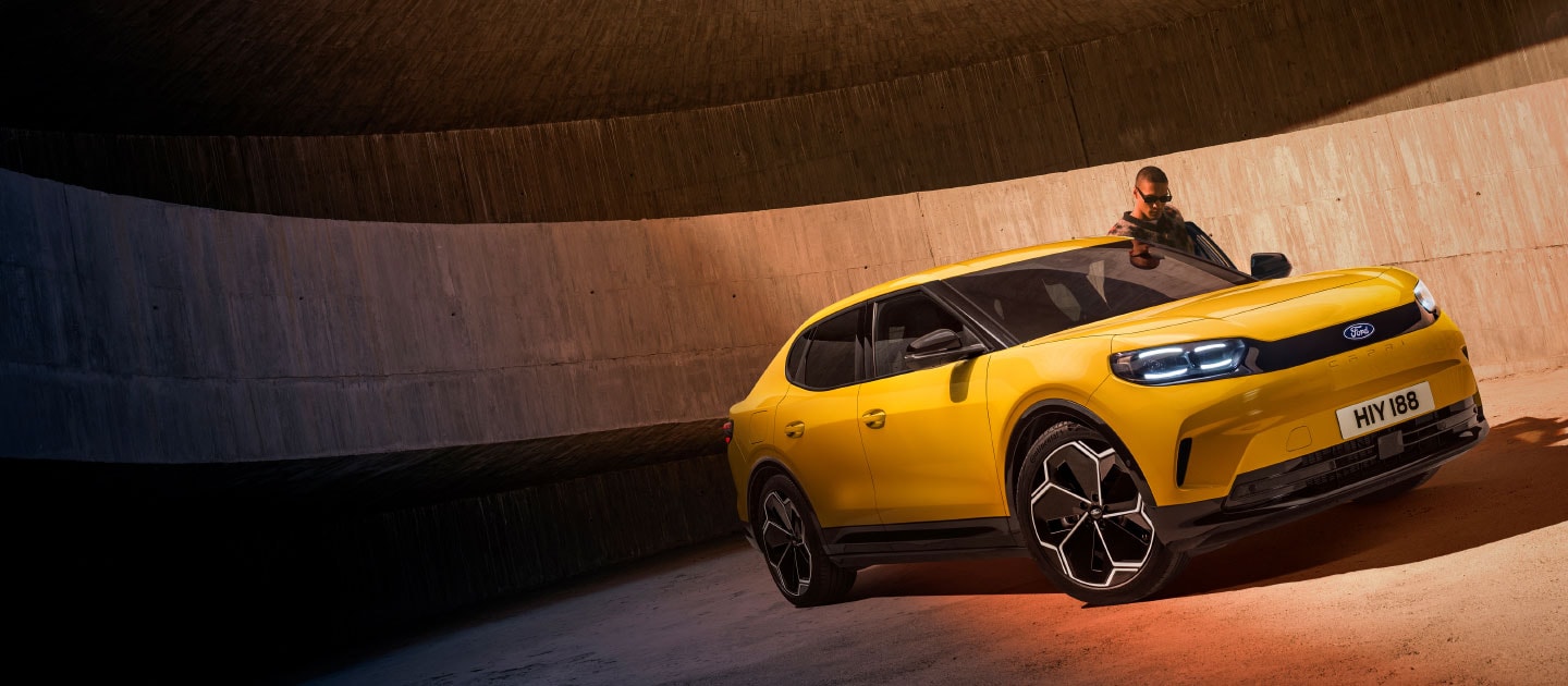 Un nouveau SUV électrique Ford Capri® jaune garé dans un parking.